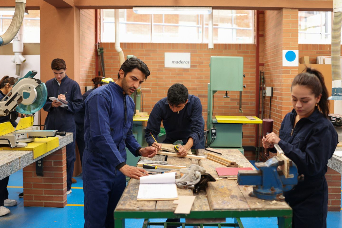 People learning construction on a work bench