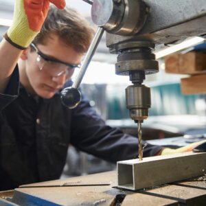 Apprentice drilling in a fabrication business