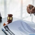 Lawyers at a desk with a gavel, documents, and justice scales.