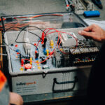 Person working on an electrical training kit.