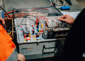 Person working on an electrical training kit.