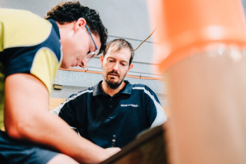 Trade instructor guiding student during hands-on workshop training