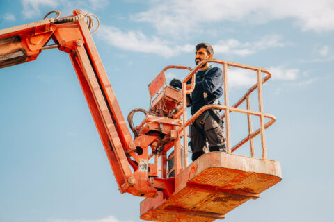 Operator working at height using elevated work platform lift
