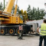 Crane truck on site with worker in hi-vis vest