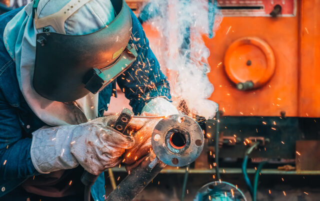 Welder cutting metal with sparks flying