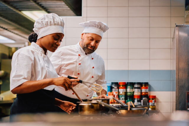 Professional chefs preparing food together in a commercial kitchen