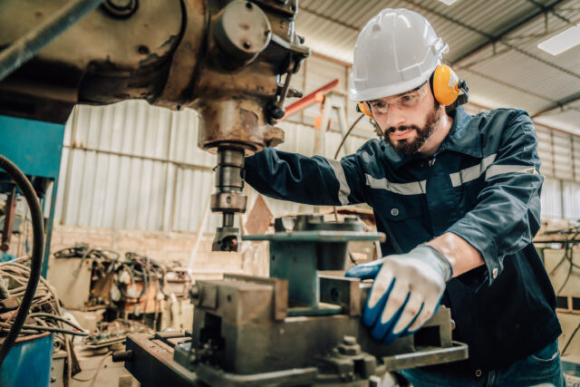 Machinery operator working on industrial drilling equipment