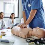 Medical student performing CPR on a dummy.