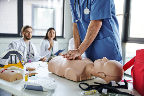Medical student performing CPR on a dummy.