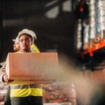 Warehouse worker carrying a large box