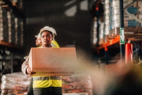 Warehouse worker carrying a large box
