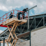 Workers installing steel framework on elevated construction platform