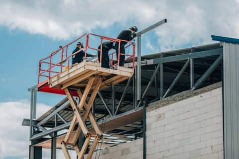 Workers installing steel framework on elevated construction platform