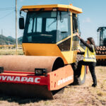 Road roller training with trainee climbing Dynapac compactor